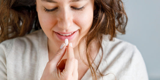 woman holding a probiotic to her mouth