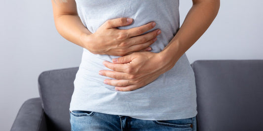 a person holding their stomach, possibly in discomfort or pain